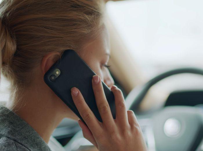 femme au volant avec son téléphone à l'oreille 